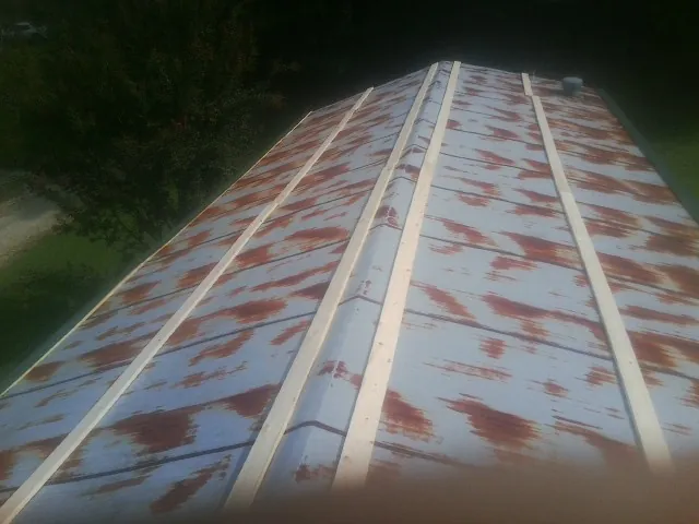 Rusted metal roof panels with new wood purlins before replacement — Storm Damage Roof Repair in Germantown by Roofing Brothers