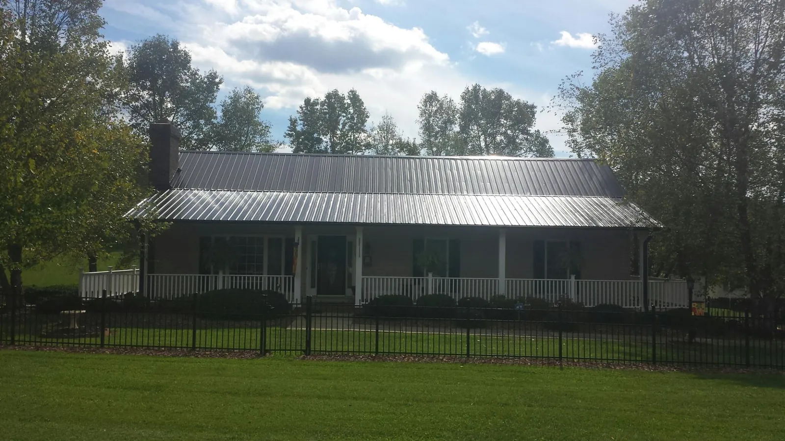 Gray metal roof on a brick ranch with a full width front porch in Germantown
